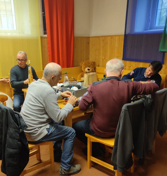 Menschen sitzen am Tisch und tüftlen